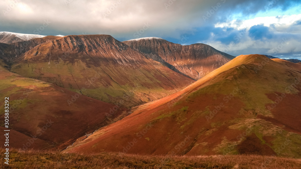 Scenic valley in autumn with snow capped mountain peaks. Touristic destination in the Lake District, Cumbria, United Kingdom. Top aerial view of peaks. Scenic valley in autumn with snow capped mountain peaks. Touristic destination in the Lake District, Cumbria, United Kingdom. Top aerial view of peaks.