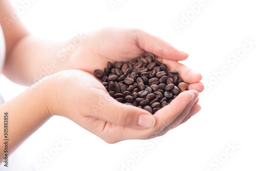 Roasted coffee beans in female hands, close up