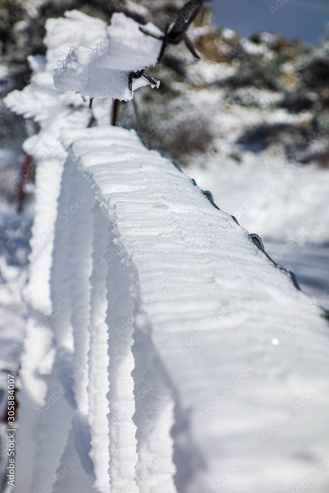 Fence covered with frozen snow on the mountain on a snowy day Fence covered with frozen snow on the mountain on a snowy day