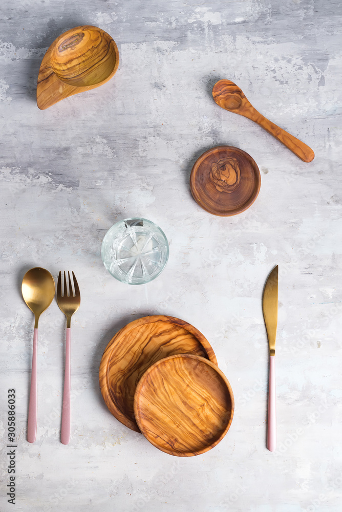 Flat lay of wooden plate and cutlery utensils on grey background. Empty plate. ,food, zero waste concept. Flat lay of wooden plate and cutlery utensils on grey background. Empty plate. ,food, zero waste concept.