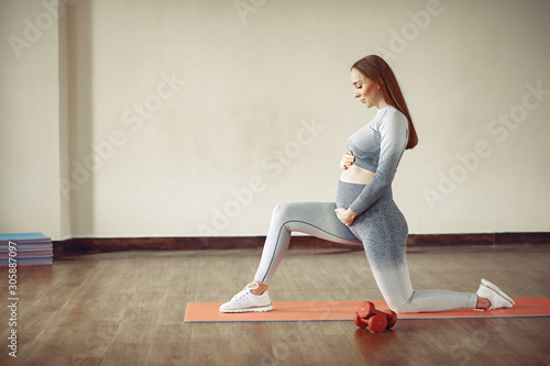 Pregnant girl in a gym. Sports girl in a sportswear.