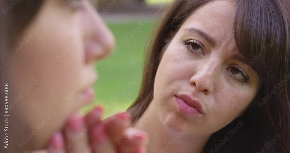 Close Up - A young woman comforts another woman outside at a park - shot on RED Close Up - A young woman comforts another woman outside at a park - shot on RED