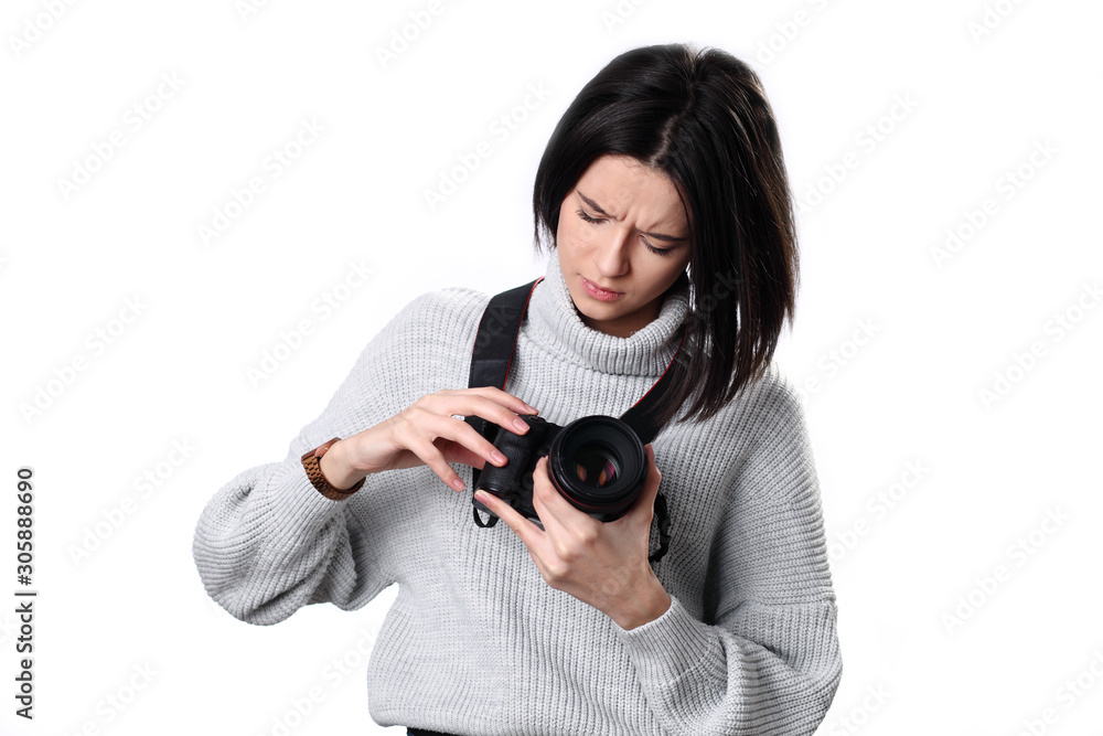 Pensive young pretty european girl photographer using modern camera, looking thoughtfully in on camera, being puzzled