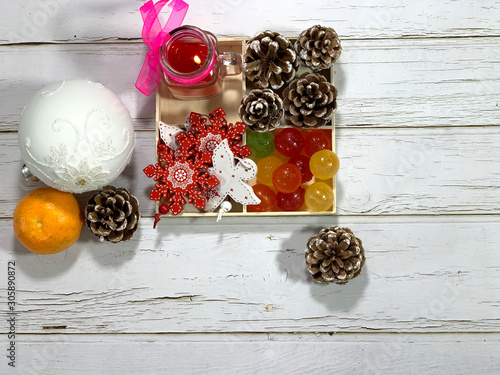 CChristmas photo with party decorations for the holiday. Wooden textured light background. Decorative wooden box with New Year's decor and Christmas decorations. Holiday card. photo