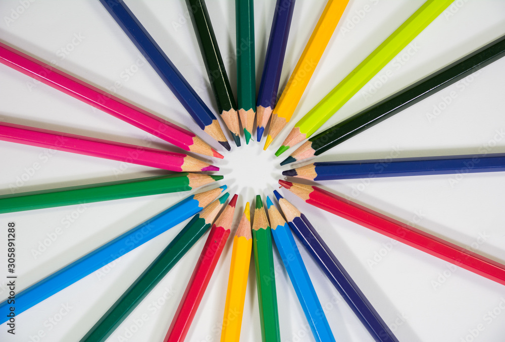 top angle view of set of color pencils in a floral flower circular shape on white backdrop top angle view of set of color pencils in a floral flower circular shape on white backdrop