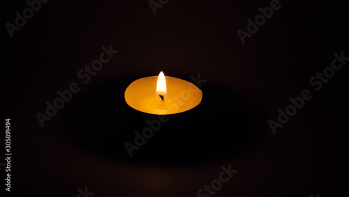 Burning candle on the table for the spa, dark background