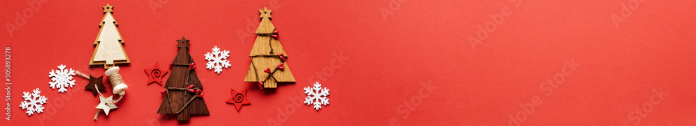 Fototapeta premium Christmas pattern made of Wooden Christmas fir tree toys, snowflakes and stars on red background. Flat lay, top view. New year concept. Top view, minimal christmas style and holiday concept. 