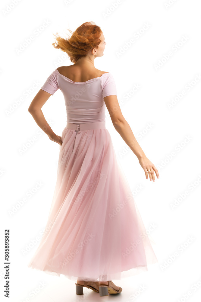 Naklejka premium A beautiful young woman stands in the wind, the wind moves her c