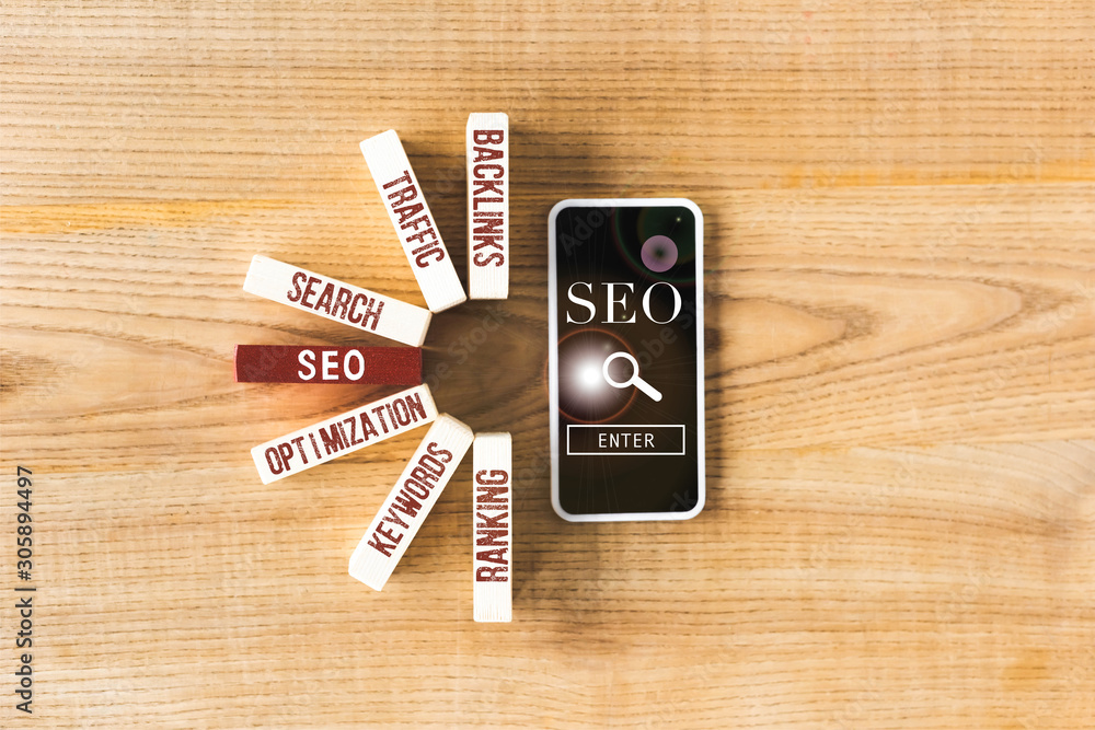 top view of wooden rectangles with concept words of seo and smartphone with seo illustration top view of wooden rectangles with concept words of seo and smartphone with seo illustration