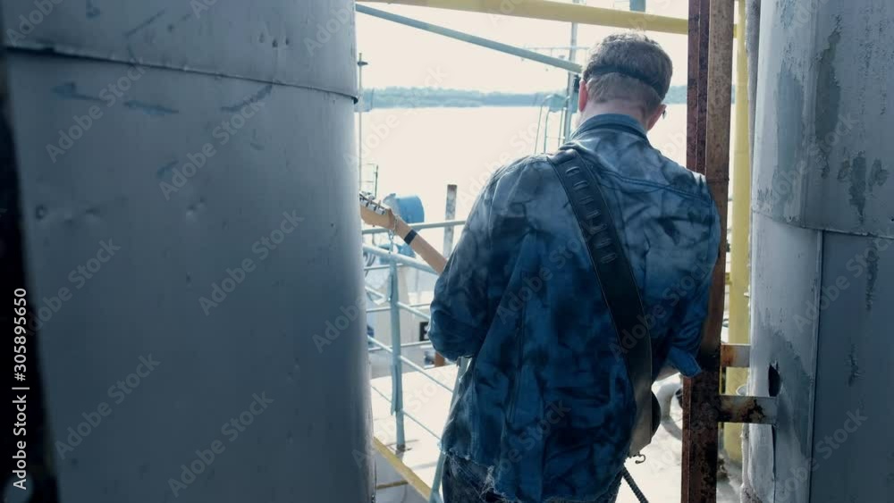 Person stand with guitar on quay ship close up hand playing cool rock music 4K. Person stand with guitar on quay ship close up hand playing cool rock music 4K.