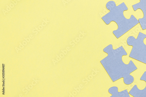 Puzzle pieces on yellow background. Top view. Copy space.