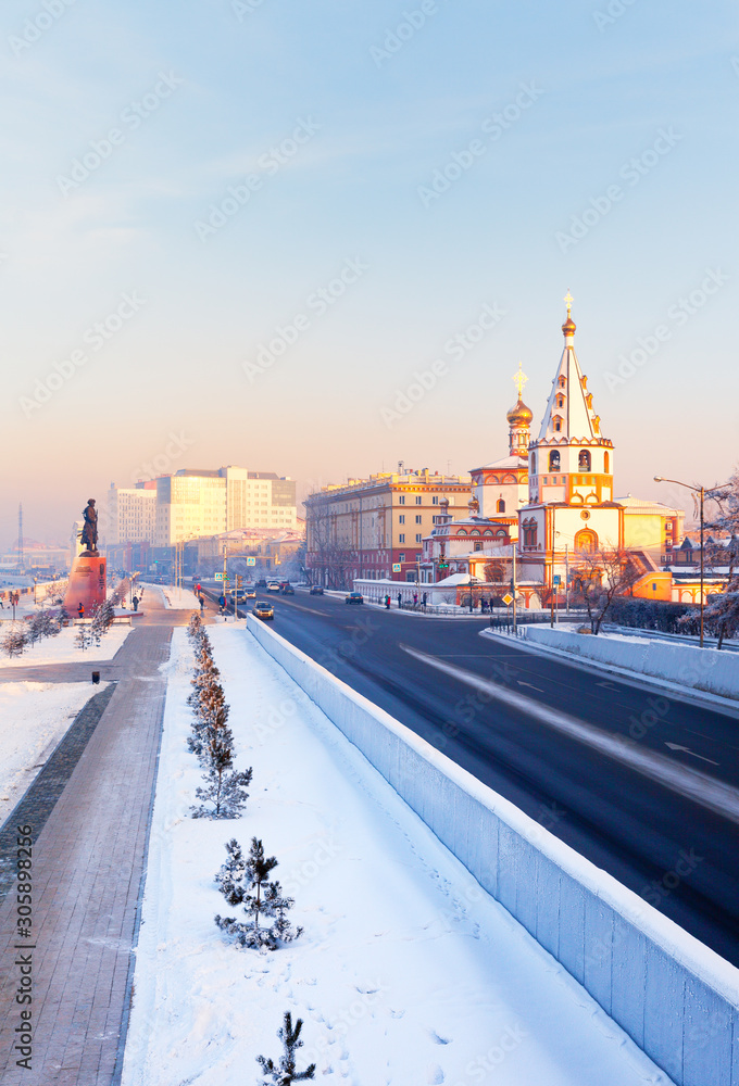 Irkutsk. View of the Lower Embankment of the Angara River with the famous old Cathedral of the Epiphany during Christmas holidays at sunset. Beautiful cityscape