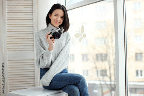 girl with a camera sitting by the window Free Download girl with a camera sitting by the window - GFXLoad