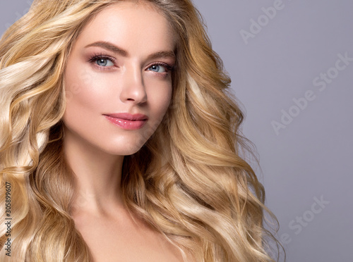 Blonde woman long curly hair face close up beautiful female natural makeup