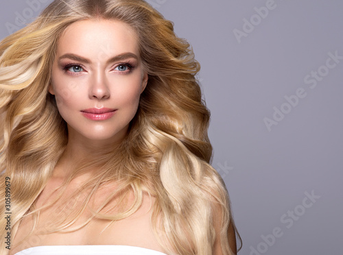 Blonde woman long curly hair  face close up beautiful female natural makeup photo