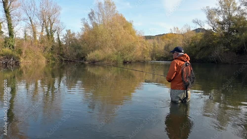 fly fisherman in river in autumn fly fisherman in river in autumn