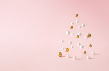 Christmas composition. Pink Christmas tree, with decoration on pink background. Happy holidays. new year minimal concept.
