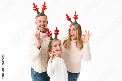 Image of beautiful family in Christmas reindeer antlers gesturing ok sign