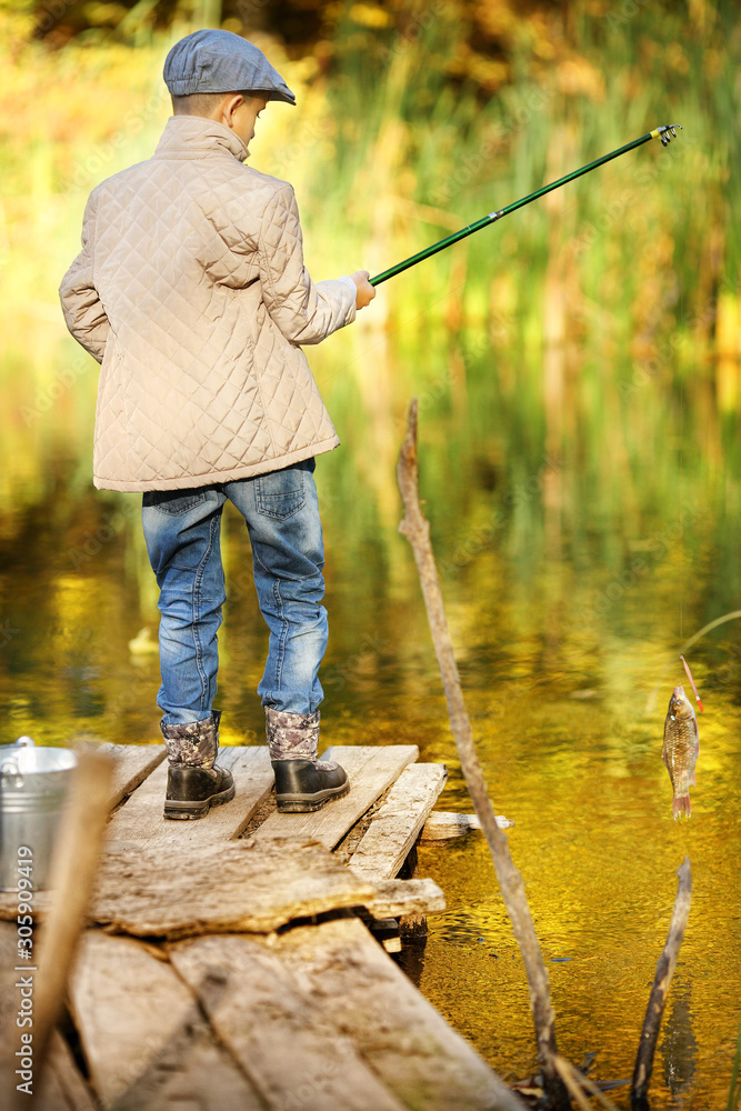 Boy is fishing at sunset on the lake Boy is fishing at sunset on the lake