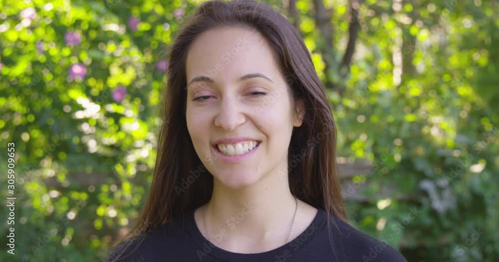 Close Up - Pretty woman looks into the camera with a smile against a park background - Slow Motion - shot on RED Close Up - Pretty woman looks into the camera with a smile against a park background - Slow Motion - shot on RED