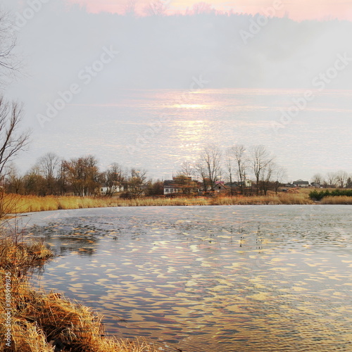 The mixed image of the view of the ice on the surface of the lake and the natural background of the view of the lake shore at the cold spring day at the City Park. 