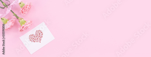 Beautiful, fresh elegant carnation flower bouquet with white greeting thanks gift card isolated on bright pink color background, top view, flat lay concept.
