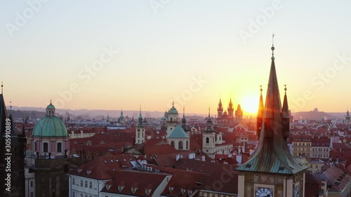 Wallpaper Mural Aerial view old town district in Prague at sunrise. Cityscape from high, drone flying at low above roof of buildings in downtown, first sun light shining on spire of clock tower at early morning Torontodigital.ca