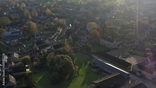 Dolly aerial view of Longborough, push in to St James' church in a small village near Moreton-In-Marsh in the Cotswolds Area Of Outstanding Natural Beauty, UK photo