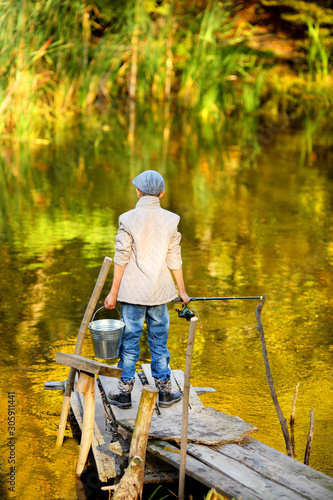 Boy Catching a Fish from wooden dock. © azhurfoto