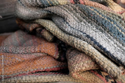 Needlework. Textile background with fabric texture with horizontal lines. A rug for home made from colorful patches of old things. Sewn in rows