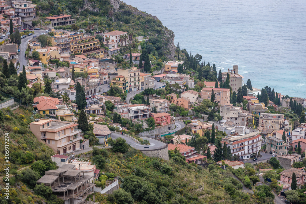 Aerial view on buildings on slopes of Taormina city seen from Castelmola, small town on Sicily Island, Italy