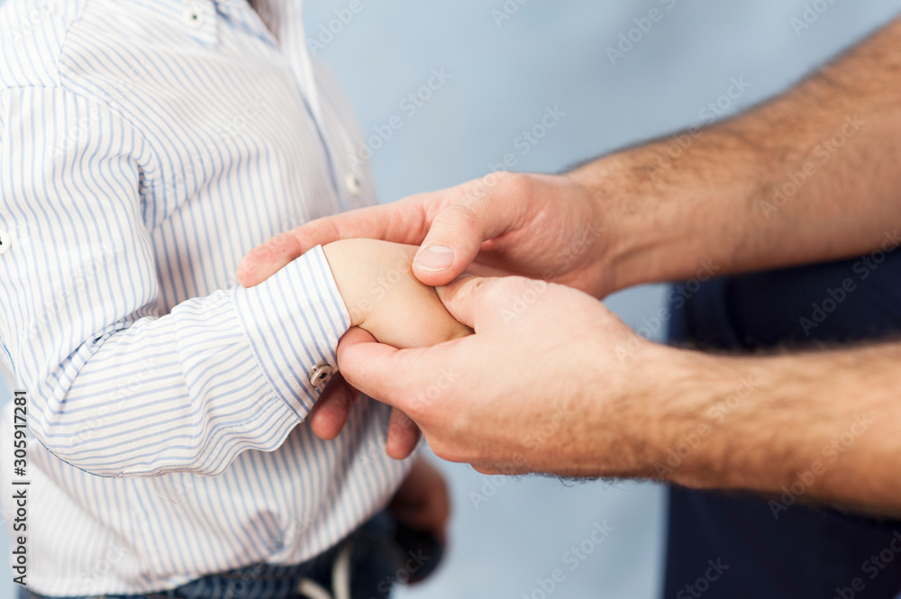 a pediatrician examines the child's hands, a dermatologist treats the hands and looks at the skin, massage the hands and fingers.Concept of examination and treatment of children a pediatrician examines the child's hands, a dermatologist treats the hands and looks at the skin, massage the hands and fingers.Concept of examination and treatment of children