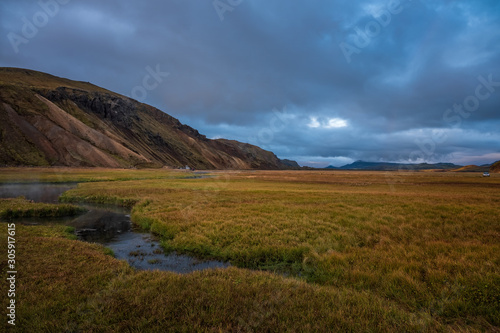 Iceland in september 2019. Great Valley Park Landmannalaugar, surrounded by mountains of rhyolite and unmelted snow. In the valley built large camp. Evening in september 2019 photo