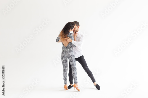 Young couple dancing social latin dance bachata, merengue, salsa. Two elegance pose on white background with copy space