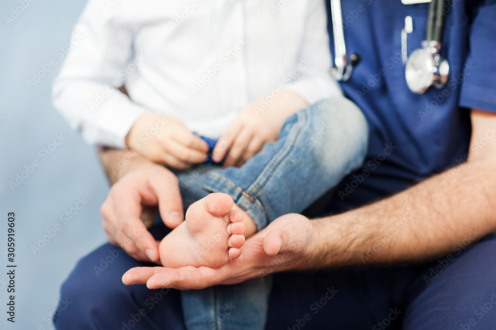 Fototapeta premium the pediatrician examines the child's feet, the dermatologist treats the heels, foot and heel massage.Concept of examination and treatment of children