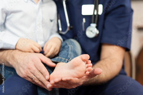 the pediatrician examines the child's feet, the dermatologist treats the heels, foot and heel massage.Concept of examination and treatment of children