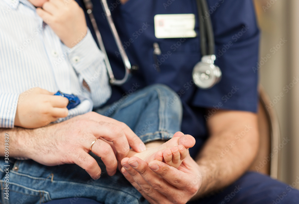 the pediatrician examines the child's feet, the dermatologist treats the heels, foot and heel massage.Concept of examination and treatment of children the pediatrician examines the child's feet, the dermatologist treats the heels, foot and heel massage.Concept of examination and treatment of children