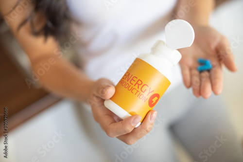 Canvas Print Young Asian female demonstrating a nutritional supplement