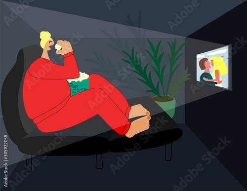 Lonely girl watching a movie in the evening at home and eating pop corn