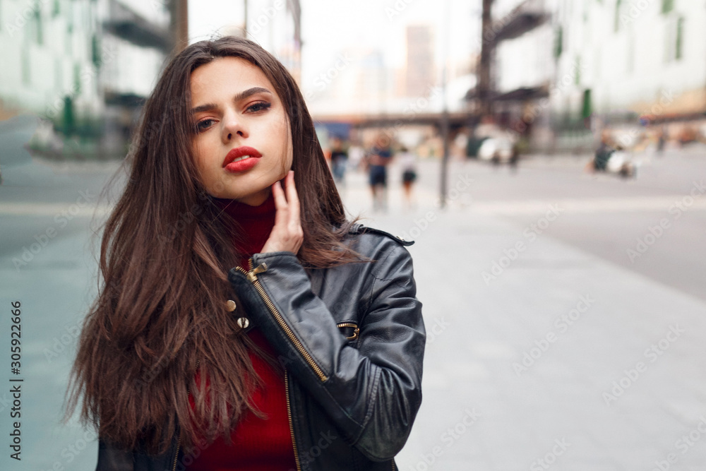 Close up portait of cute brunette girl in leather jacket, walking in the city around. Lifestyle, harmony concept. Horizontal view.