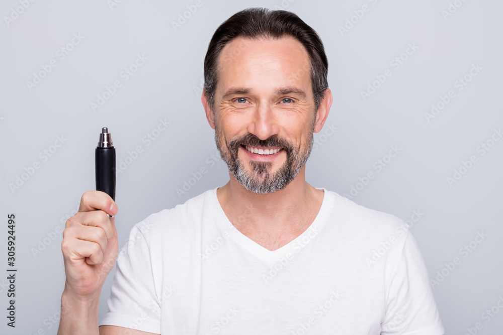 Photo of handsome mature man guy metrosexual hold best model of electric trimmer advising buyers amazing sale price wear white t-shirt isolated grey color background Photo of handsome mature man guy metrosexual hold best model of electric trimmer advising buyers amazing sale price wear white t-shirt isolated grey color background