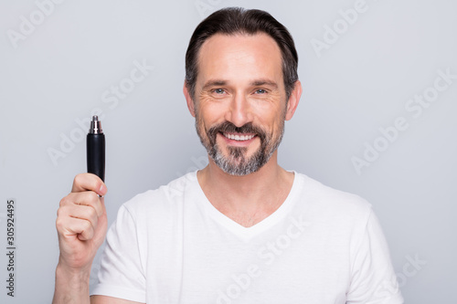 Photo of handsome mature man guy metrosexual hold best model of electric trimmer advising buyers amazing sale price wear white t-shirt isolated grey color background