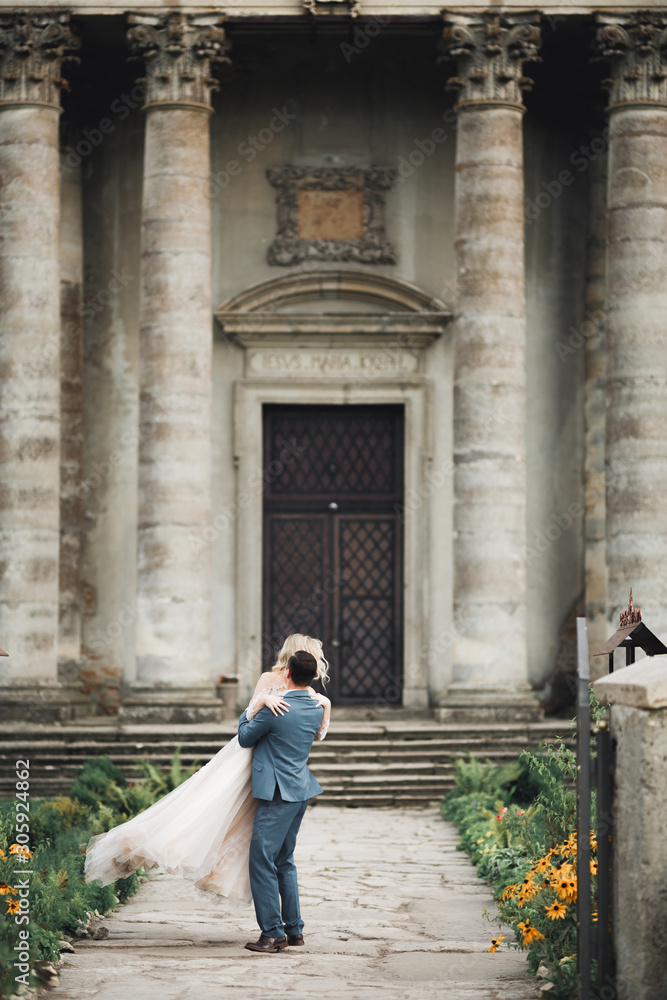 Beautiful wedding couple spinning near great historical building