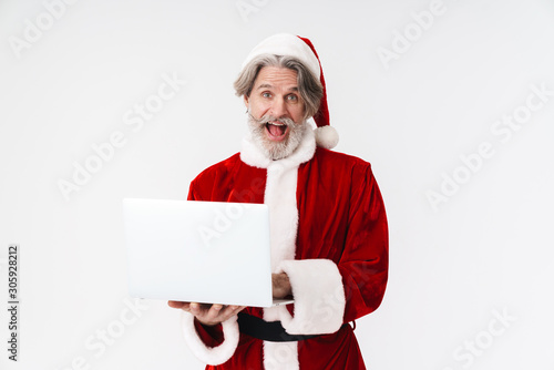 Portrait of astonished old man holding and using laptop