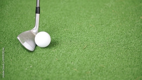 Image of golf iron and golf ball on green grass