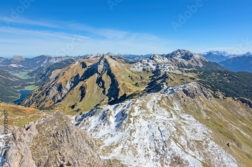View from the summit of a mountain at a beautiful day in autumn to the Allgau Alps (Tyrol, Austria). Alpine landscape with rocky mountains, colorful pastures, blue sky. © Andreas Föll