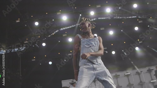 Black rapper in overalls on stage