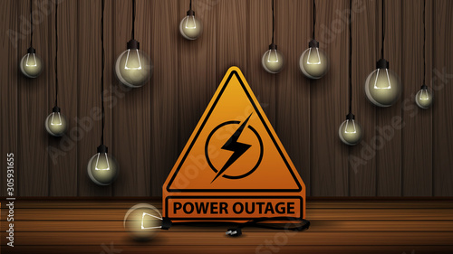 Power outage, yellow warning logo on the background of wooden wall and dull light bulbs
