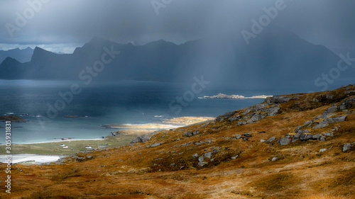 rainy autumn evening with storm clouds and the rays of the sun on the way up the mountain Ryten of Norway on Lofoten Islands 