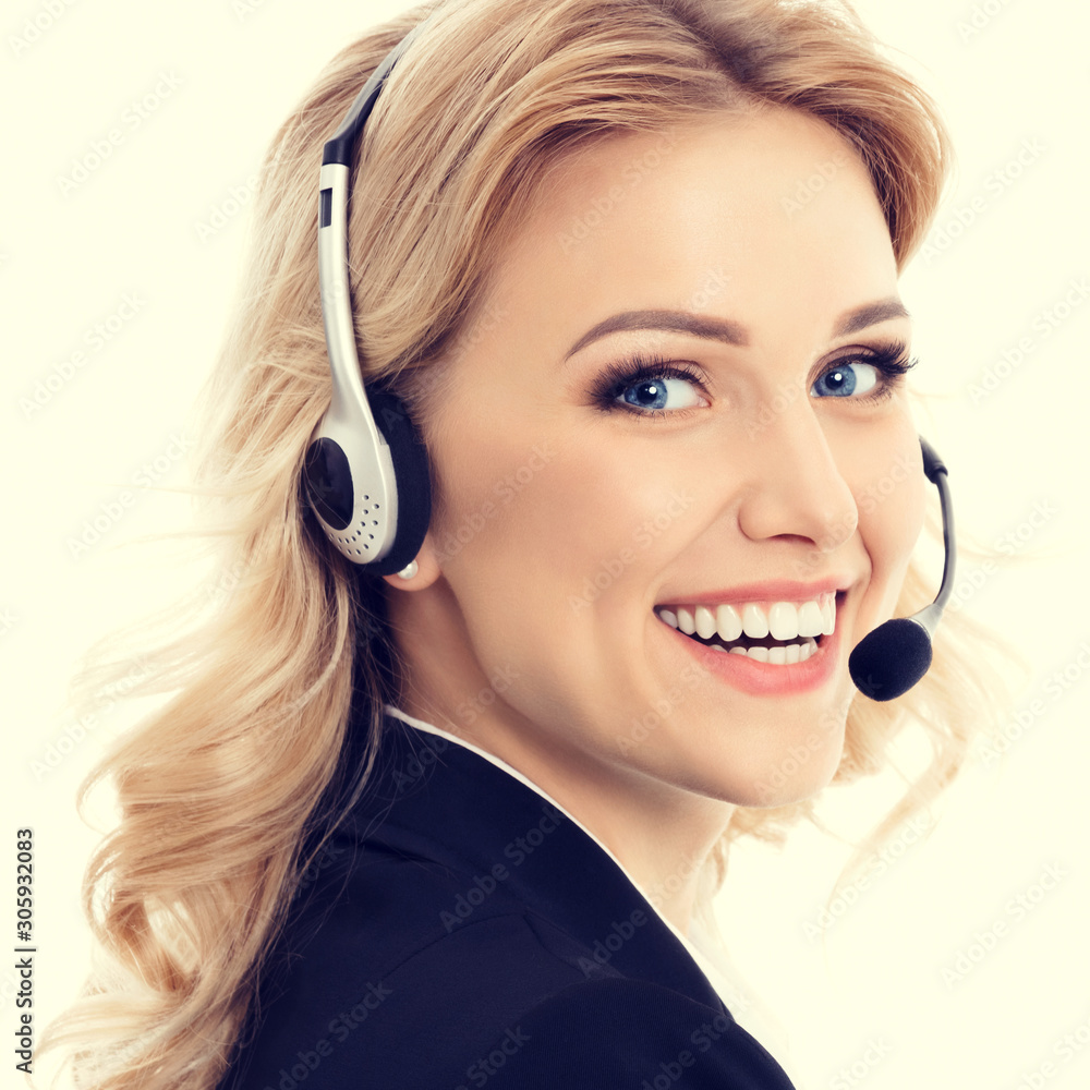 Call center. Smiling young support phone operator in confident style black suit and headset. Caucasian blond model in customer service help consulting concept.